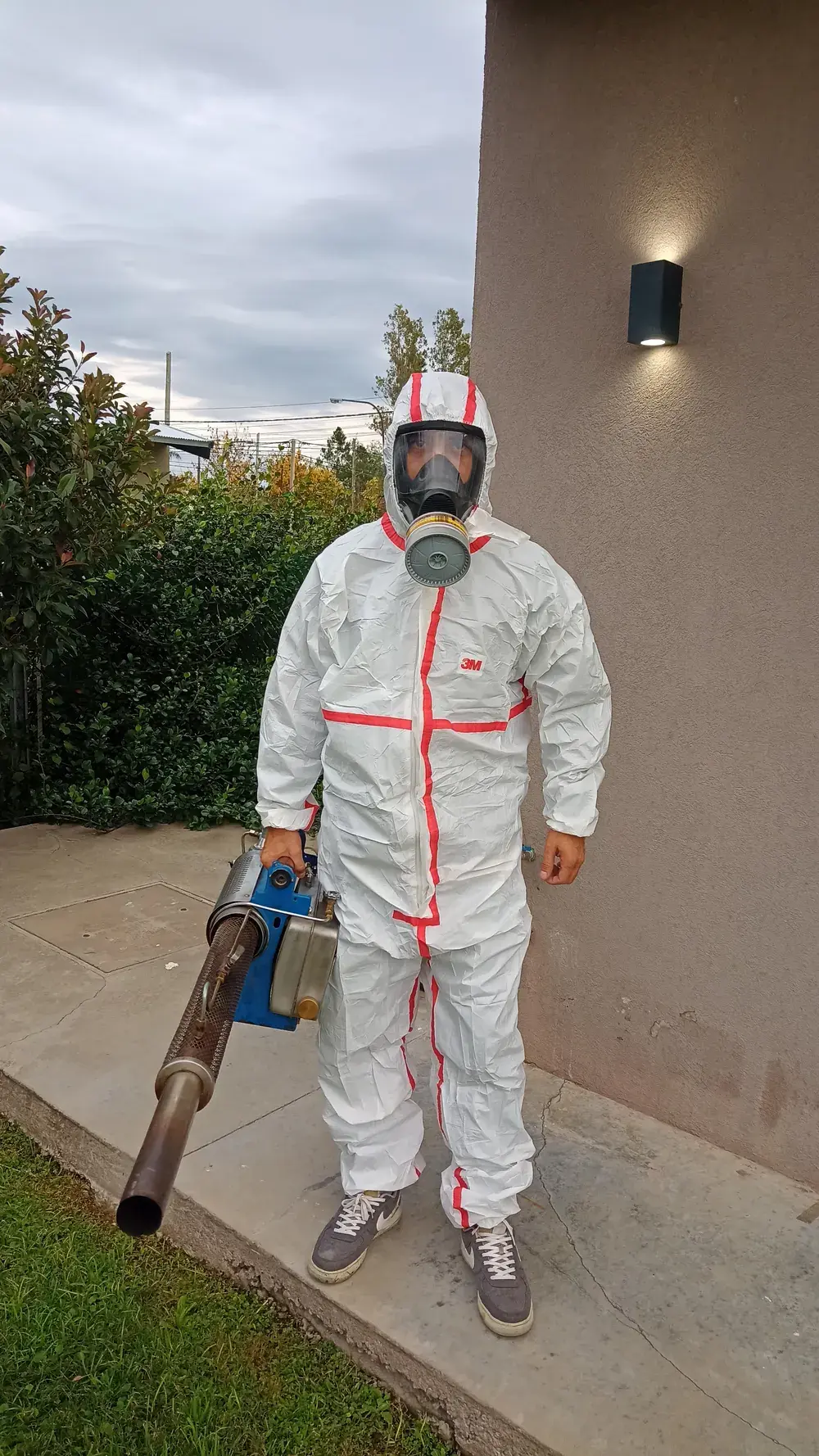 Técnico real de CG Fumigaciones con traje 3M y equipo de termonebulización